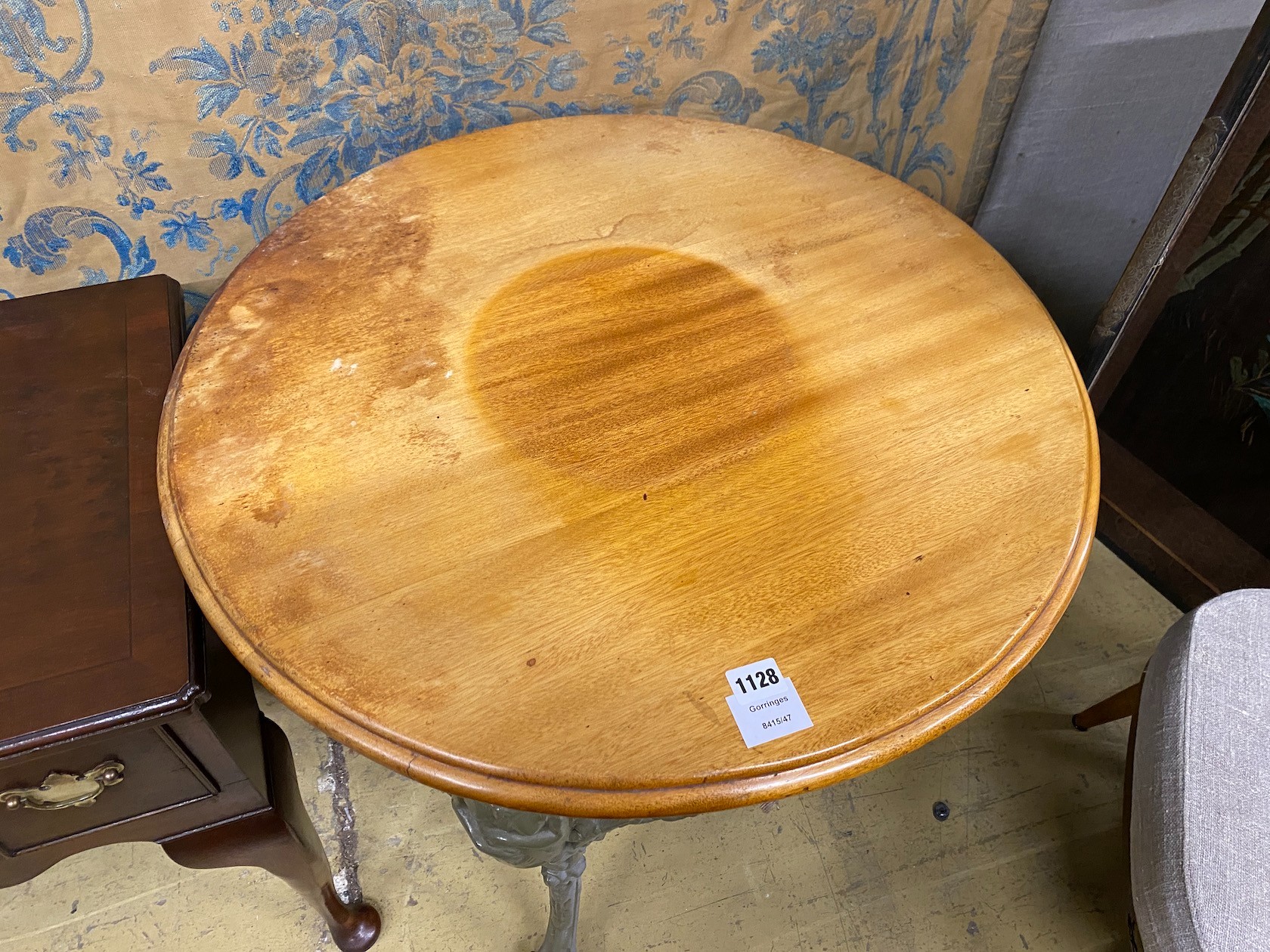 A painted cast iron Britannia pub table with circular mahogany top, diameter 68cm, height 76cm